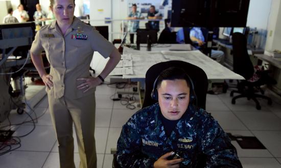 A Navy Reserve lieutenant commander from the Office of Naval Research (ONR) Reserve Component observes a junior surface warfare officer from Destroyer Squadron 31 call out contacts during an ONR demonstration of improved training that combines software and gaming technology. Navy active-duty commands should work closely with their Reserve components to ensure the best support.